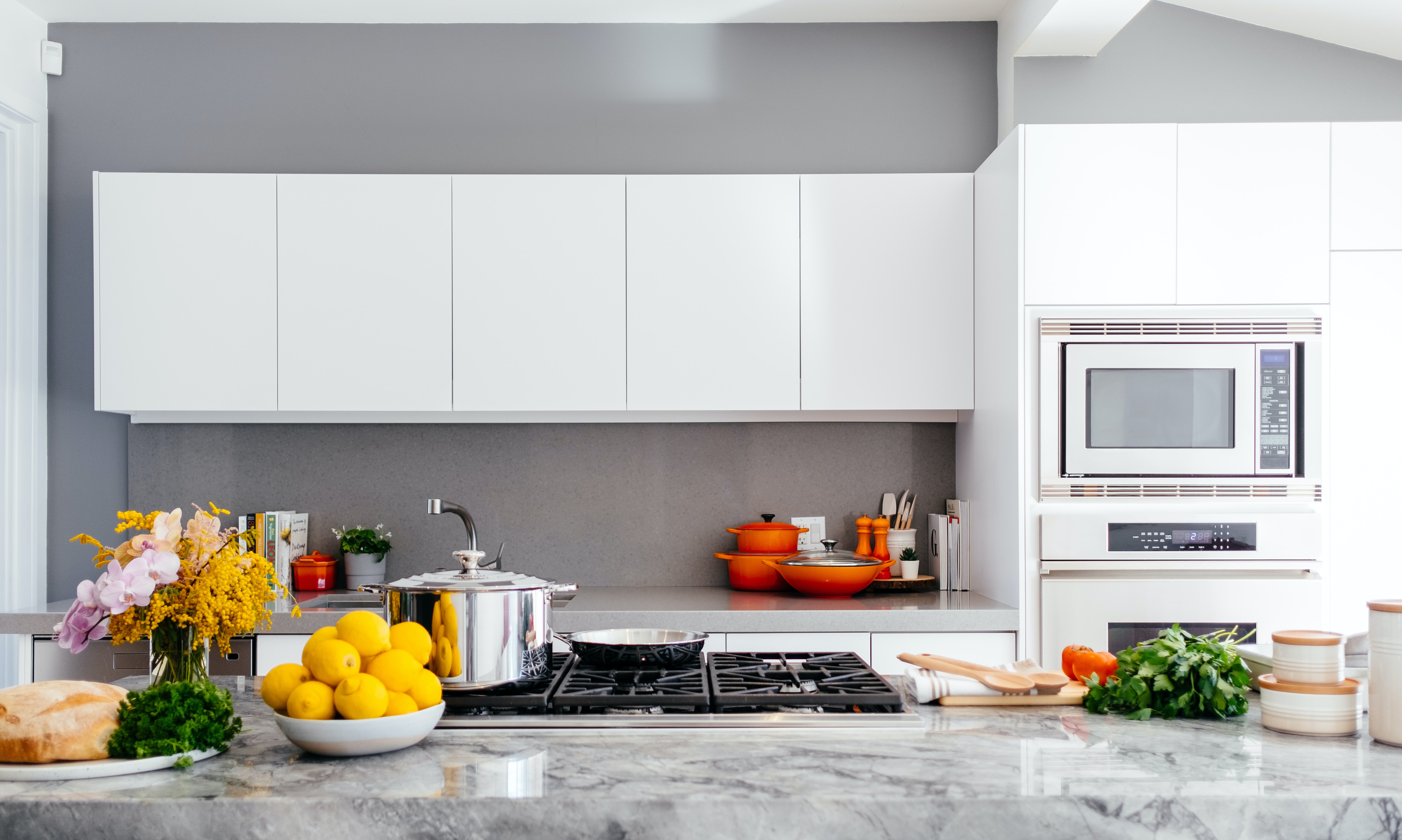 Clean modern kitchen with worktops, cooker and food preparation ingredients laid out on counter